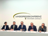 Frau Dr. Prof. Ariane Berger, Geschäftsführendes Präsidialmitglied des Landkreistages Sachsen-Anhalt, Landrat Mansfeld-Südharz André Schröder, Landrat Salzlandkreis Markus Bauer, Landrat des Burgenlandkreises und Präsident des Landkreistages Sachsen-Anhalt, Götz Ulrich (v.l.n.r.), sitzen auf einem Podium bei der Landespressekonferenz Sachsen-Anhalt. Sie sprechen über die Verfassungsbeschwerde zur finanziellen Mindestausstattung der Landkreise gemäß Artikel 28 Grundgesetz.