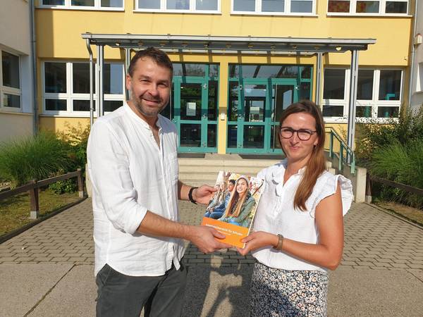 Amtsleiter Robert Brückner übergibt Frau Fischer-Weißenfels, Schulleiterin der Pestalozzischule Naumburg, eine Angebotsübersicht.